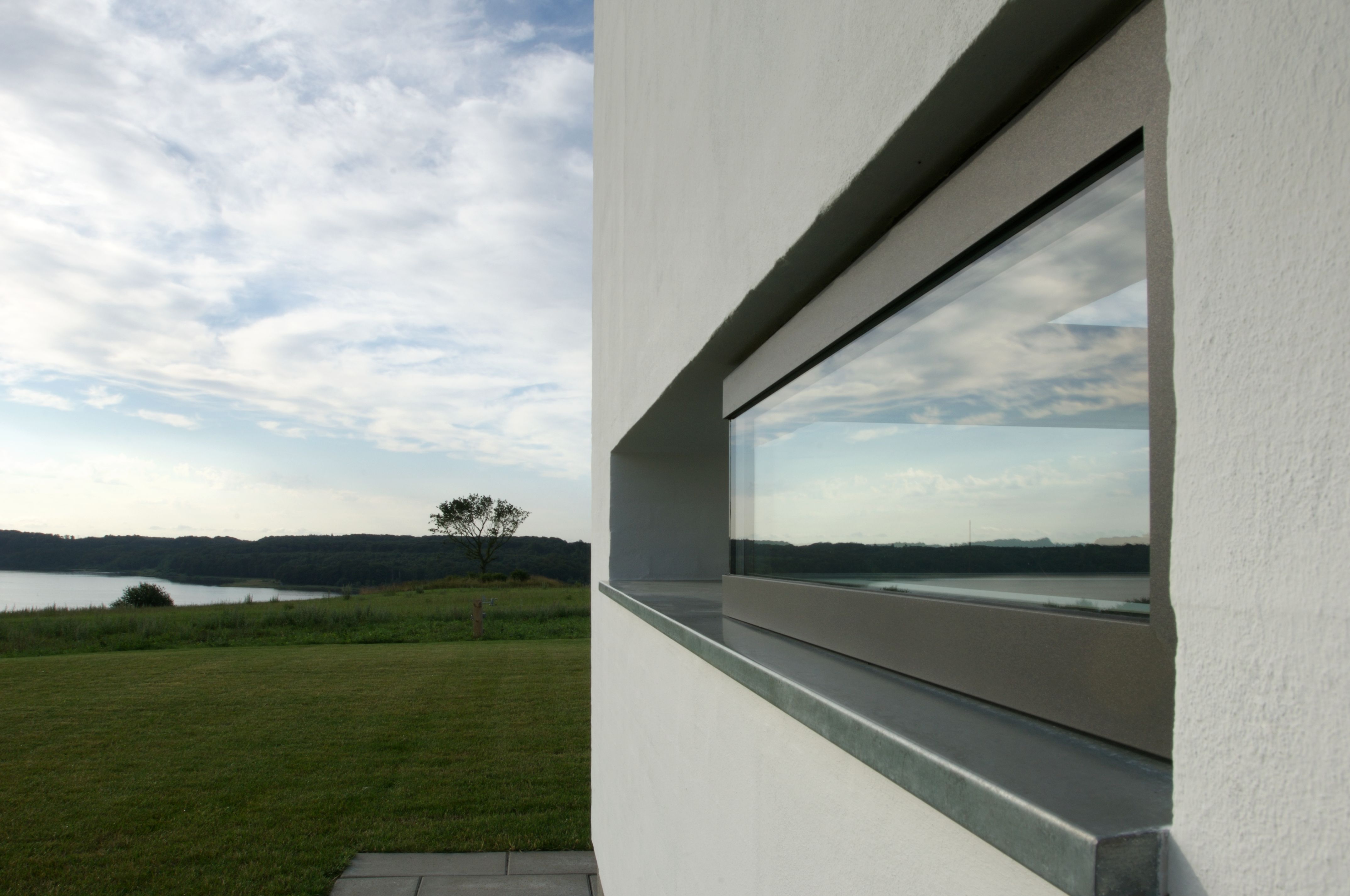 Hvid murstenshus med vandret aflangt vindue.