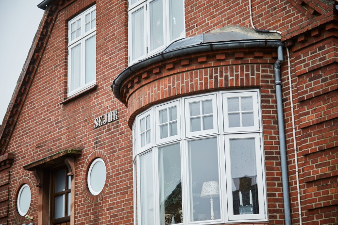 Rød murermestervilla med karnapvinduer